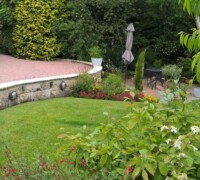 Stone driveway with step down to garden with patio area and Range Rover