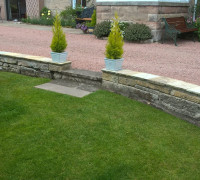 stone driveway with step down to garden