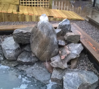 Water feature flowing into back garden pond