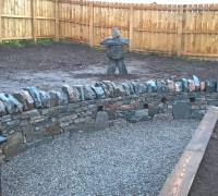 Natural stone wall with stone figure